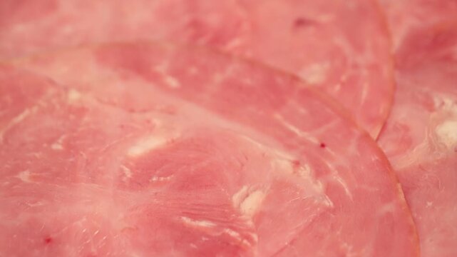 Close-up of turkey ham texture. Sliced deli meat background, protein food and processed poultry meat concept. High quality 4k footage