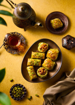 Turkish baklava on a copper plate and a glass of tea. Yellow background. Top view.