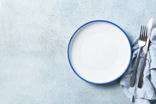 Minimalist table setting template with empty dish for restaurant food placement. Background for culinary card, recipe banner or menu layout. Copy space. Top view.