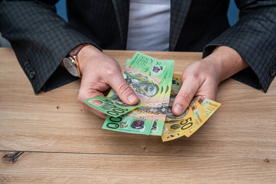 Top View of Businessman Using Blue Calculator and Counting Australian Dollar Money Banknotes