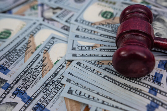 Judge Gavel Resting on One Hundred US Dollar Bills for Legal Compensation and Lawsuit Concept