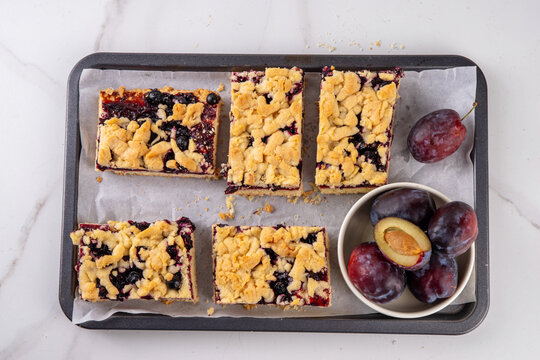 Traditional German Zwetschgenkuchen, plum open pie with crumbled streusel dough topping. Sweet autumn seasonal sweet shortcrust fruit cake