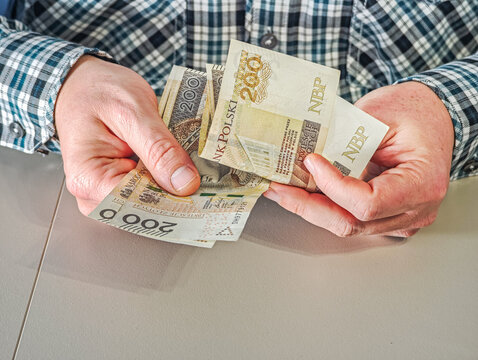Man holding fan of 200 Polish Zloty banknotes PLN currency, financial success and wealth concept