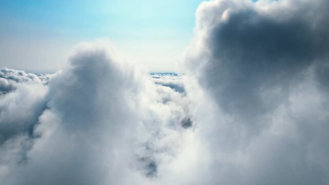 Aerial view of white cumulus clouds under a clear blue sky during daytime, ideal for background or flight concept imagery.