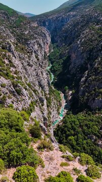 Aerial drone view of the turquoise Verdon River flowing through the Verdon Gorge river canyon in the Provence-Alpes-Cote d'Azur region of southeastern France. High quality 4k footage