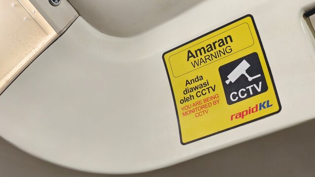 Kuala Lumpur, Malaysia - 01 August 2026: Yellow RapidKL CCTV warning sticker mounted on the interior panel of a public transit vehicle.