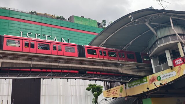 Kuala Lumpur,Malaysia - 01 August 2026: Red monorail train approaching Bukit Bintang station with Isetan department store background.