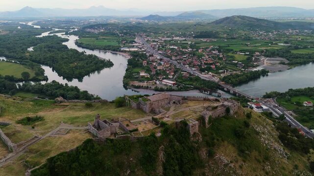 Aerial drone view of Shkod&euml;r at sunset, overlooking Lake Shkodra, winding rivers, and Rozafa Castle in Albania. Atmospheric evening twilight landscape