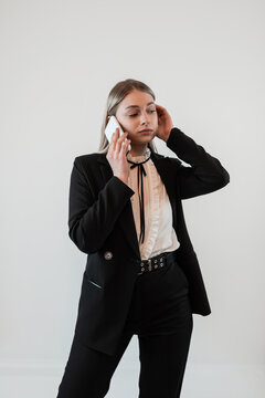 Portrait of happy young caucasian business woman using smartphone on isolated white gray background