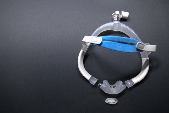 Disassembled CPAP nose mask or nasal CPAP cradle mask shows replaceable parts of CPAP headgear clip. Sleep apnea and sleep disorder with snoring stopped by respirator mask and CPAP machine treatment.