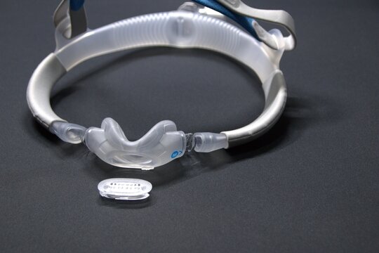 Disassembled CPAP nose mask or nasal CPAP cradle mask shows replaceable parts of CPAP headgear clip. Sleep apnea and sleep disorder with snoring stopped by respirator mask and CPAP machine treatment.