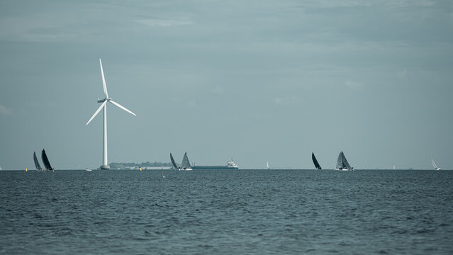 Offshore Wind Turbine, Sailboats, and Cargo Ship on the Sea
