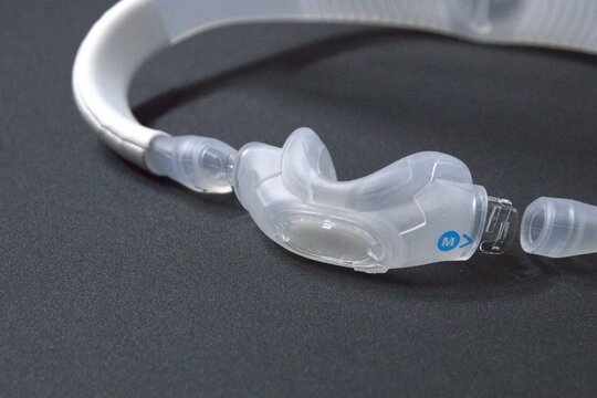 Disassembled CPAP nose mask or nasal CPAP cradle mask shows replaceable parts of CPAP headgear clip. Sleep apnea and sleep disorder with snoring stopped by respirator mask and CPAP machine treatment.