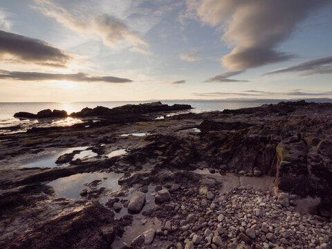 Sunset over rocky shore by the sea