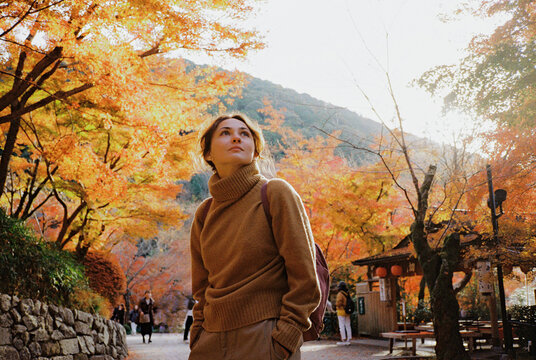 Woman walking along the pathway in autumn in Japan 