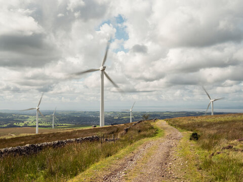 Wind farm on rolling hills with dirt path