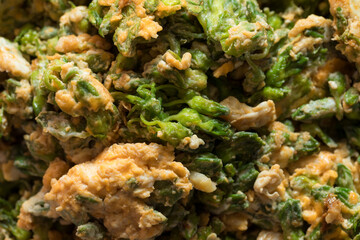 Fototapeta premium Close-Up of Stir-Fried Cowslip Creeper Flowers (Dok Kajon) with Eggs Cooking in a Frying Pan, Traditional Homemade Thai Cuisine