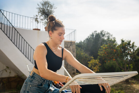 Woman arranging fresh laundry outdoors