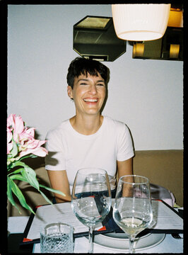 Happy woman with short hair smiling at dinner