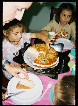 Family celebrating holiday with Roscon de Reyes cake