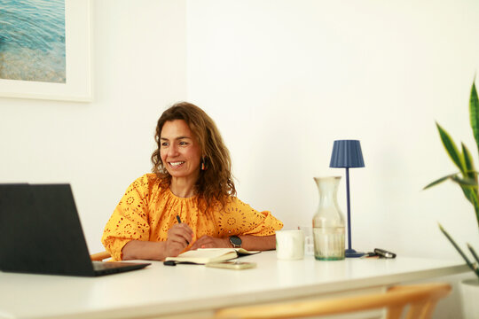 Woman Smiling While Working at Desk