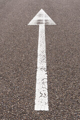 arrow straight ahead on asphalt road