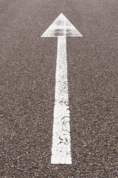 arrow straight ahead on asphalt road