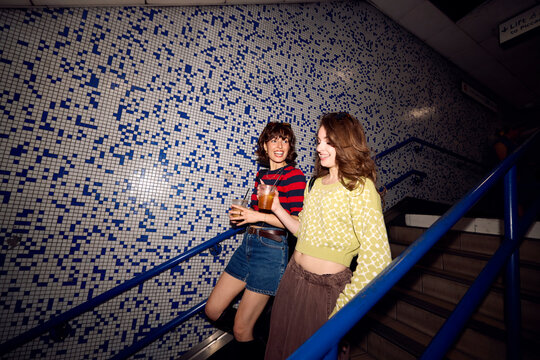 Two attractive women made their way to the subway station.