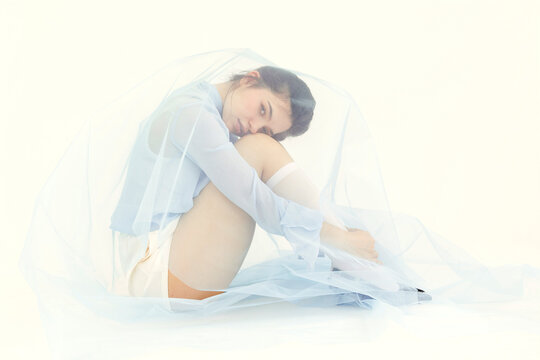 Woman creating isolation with blue veil fabric