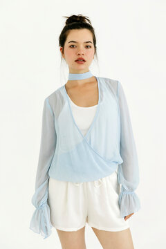 Woman modeling light blue sheer blouse