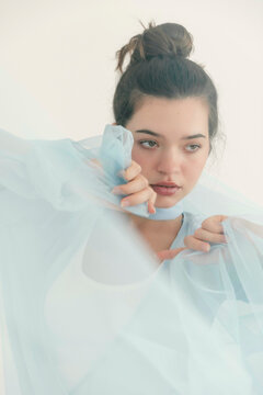 Woman holding sheer blue fabric 