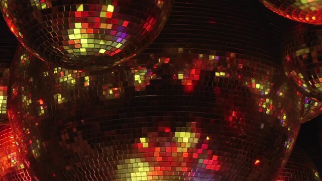 Vibrant disco balls create dazzling display of colorful reflections inside lively nightclub. Festive red, blue, green, and purple lights swirl, celebrating magic of Christmas with joyous glow.