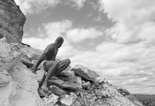 Man Sitting on Rocks Outdoors During Daylight in a Remote Area