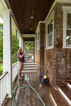 Spring Window water hose  Clean man on ladder 