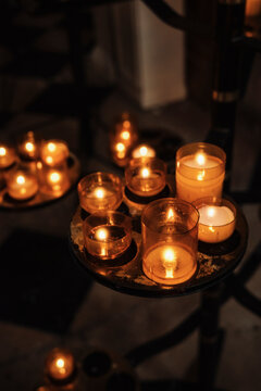 Candles Are Lit on Different Stands in a Dim Space During Evening