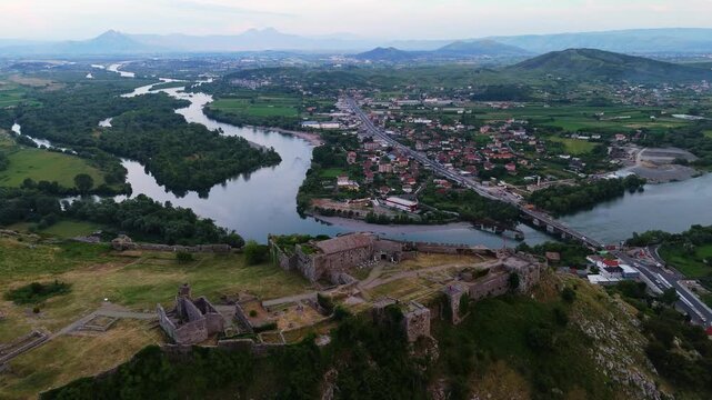 Aerial footage of Berat Castle rising above the historic city of Berat, revealing traditional Ottoman houses, fortified walls and the surrounding mountain landscape of central Albania 