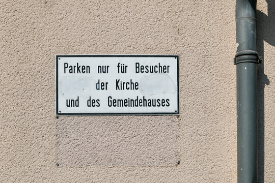 Hinweisschild "Parken nur f&uuml;r Besucher der Kirche" an Geb&auml;udewand