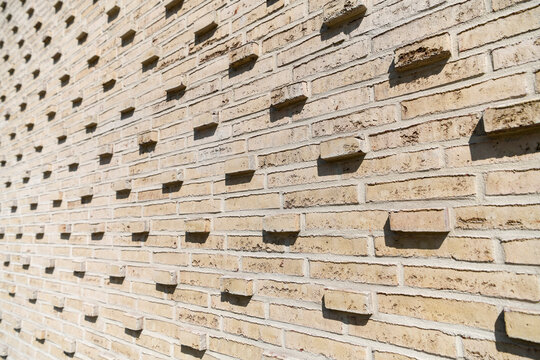 Perforierte Ziegelfassade mit geometrischem Lochmuster in Diagonalperspektive
