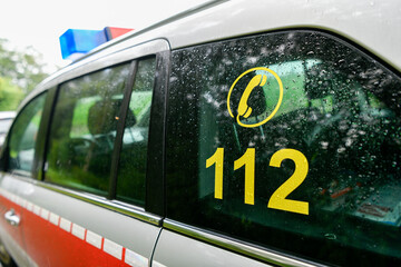 Fototapeta premium Notruf 112 Symbol auf Fahrzeugscheibe eines Einsatzfahrzeugs im Regen