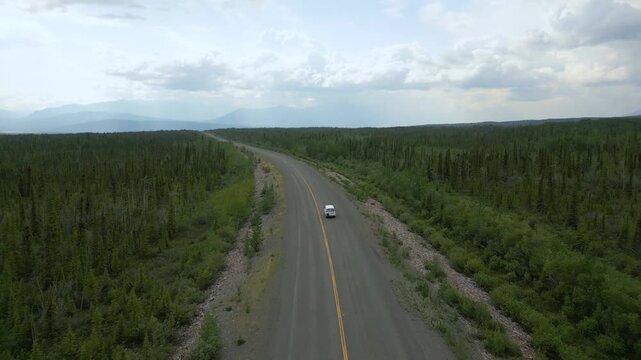 Camper van drone aerial view driving remote road through Yukon wilderness in Canada