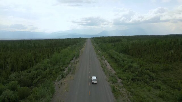 Camper van drone aerial view driving remote road through Yukon wilderness in Canada