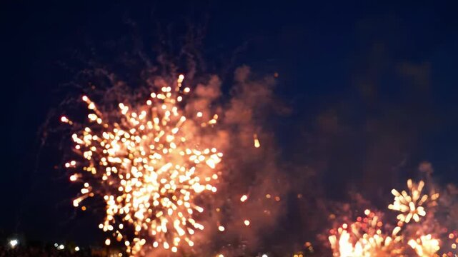 Bright golden fireworks exploding in the night sky