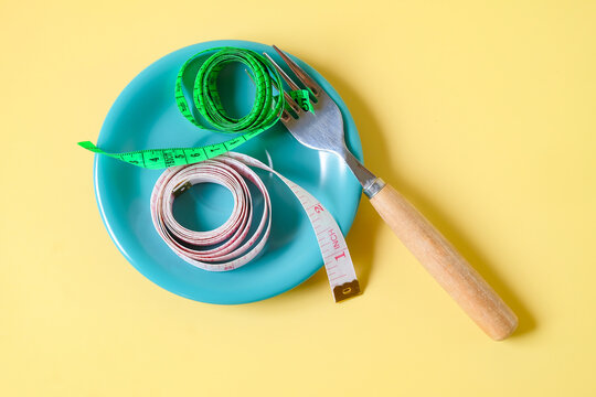 Measuring tape on dish with fork,Diet concept.