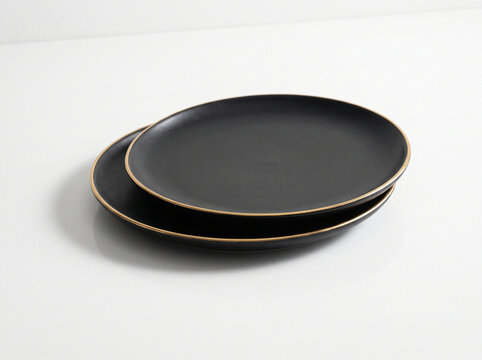 Elegant Matte Black Serving Plates with Gold Rim on White Surface