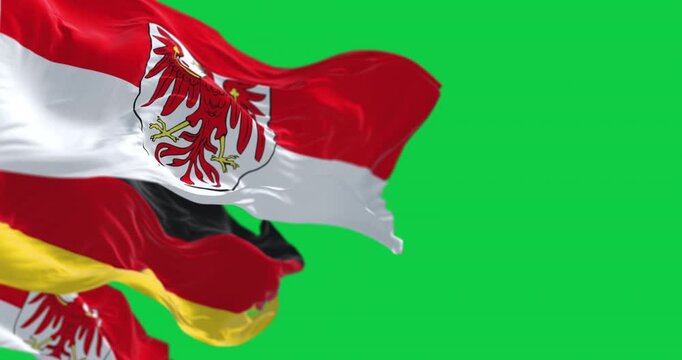 Germany and Brandenburg state flags waving isolated on green background
