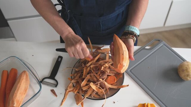 Woman Peeling A Raw Sweet Potato In A Closeup Top-Down View