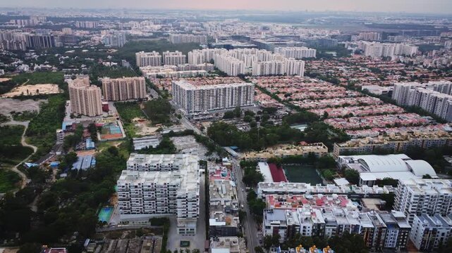Aerial drone view of rapidly expanding residential and commercial real estate in Bangalore, Karnataka, India, featuring modern apartment complexes, construction projects, and the city's fast-growing u
