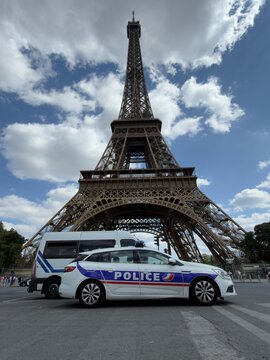 Two French police patrol vehicles stationary in front of the Eiffel Tower in Paris conducting routine anti-terror patrols. 