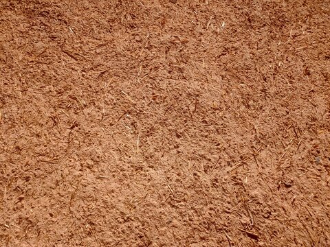 Traditional earthen wall texture with red clay and straw, Rough red clay earthen wall with straw texture