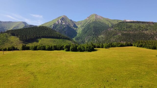 Aerial footage of the Belianske Tatry in Slovakia, featuring the mountain peaks Zdiarska Vidla and Havran. The view captures the dramatic ridgelines, rocky slopes and green alpine landscape